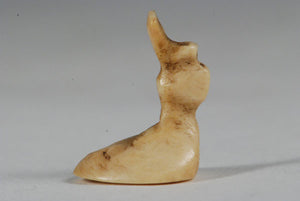 A miniature ancient Inuit game piece carved from walrus ivory