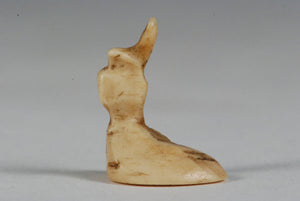 A miniature ancient Inuit game piece carved from walrus ivory